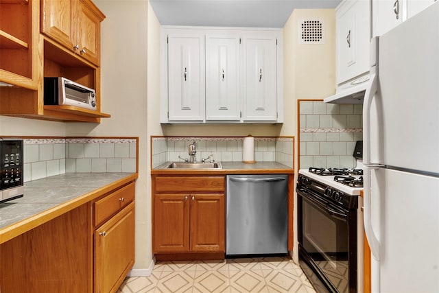 395 Westchester Ave Unit 3A, Port Chester, NY 10573 - kitchen featuring freestanding refrigerator, stainless steel dishwasher, gas range oven, tile countertops, and white cabinets
