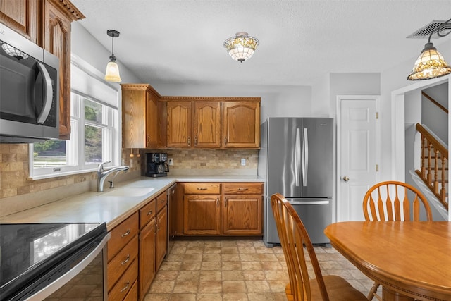 7 Brandy Ln, Hopewell Junction, NY 12590 - kitchen featuring appliances with stainless steel finishes, a sink, light countertops, decorative backsplash, and a textured ceiling