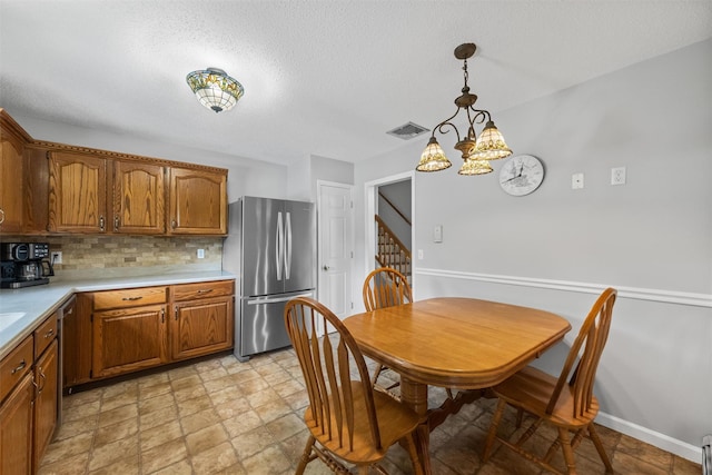 7 Brandy Ln, Hopewell Junction, NY 12590 - kitchen featuring appliances with stainless steel finishes, light countertops, brown cabinetry, tasteful backsplash, and decorative light fixtures
