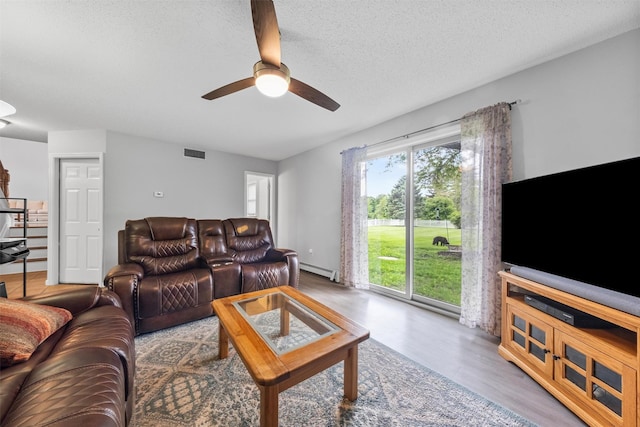 7 Brandy Ln, Hopewell Junction, NY 12590 - living room with a ceiling fan, wood finished floors, a baseboard heating unit, and a textured ceiling