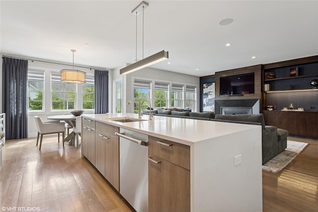 18 Rose Ln, Rye Brook, NY 10573 - kitchen with stainless steel dishwasher, a sink, modern cabinets, light countertops, and light wood-style floors