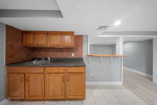199 Central Ave, Bethpage, NY 11714 - kitchen featuring a sink, baseboards, dark countertops, brown cabinetry, and recessed lighting