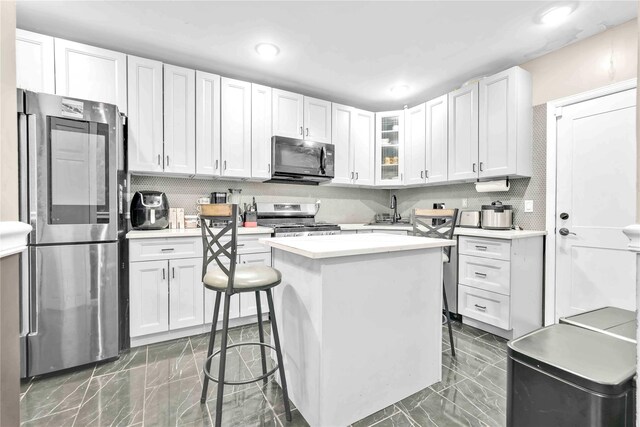 187-16 Williamson Ave, Springfield Gardens, NY 11413 - kitchen with stainless steel appliances, light countertops, dark marble finish flooring, a center island, and recessed lighting