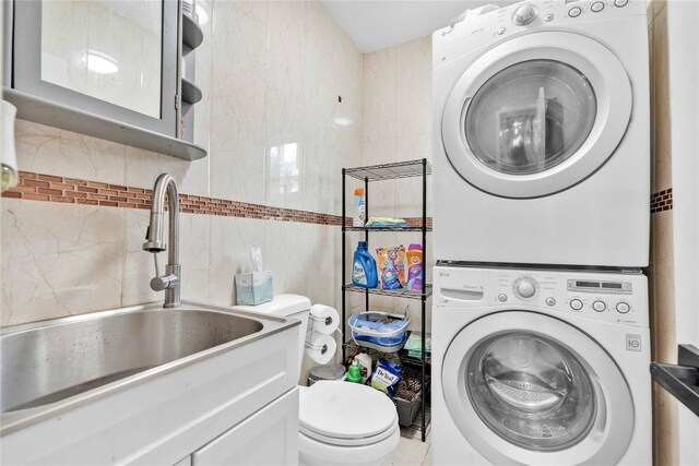 187-16 Williamson Ave, Springfield Gardens, NY 11413 - laundry room featuring stacked washer / dryer and tile walls
