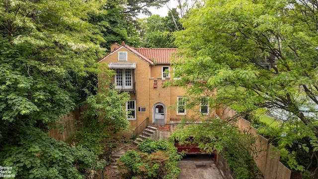 3115 Netherland Ave, Bronx, NY 10463 - view of front of house with a chimney, a tile roof, and stucco siding