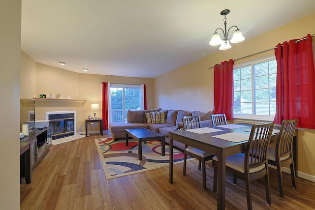 601 Covington Green Ln, Patterson, NY 12563 - dining area featuring wood finished floors, a chandelier, and a fireplace with flush hearth