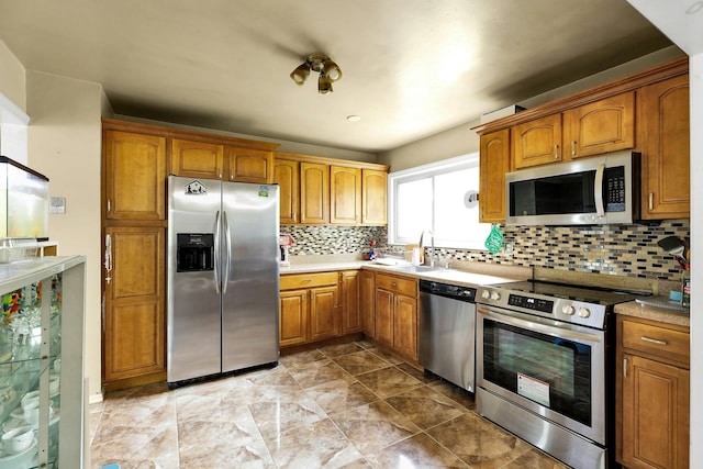 23 Berkeley Ave, Selden, NY 11784 - kitchen with stainless steel appliances, a sink, brown cabinetry, and decorative backsplash