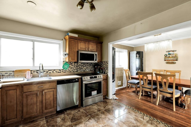 23 Berkeley Ave, Selden, NY 11784 - kitchen with stainless steel appliances, a sink, crown molding, backsplash, and a chandelier