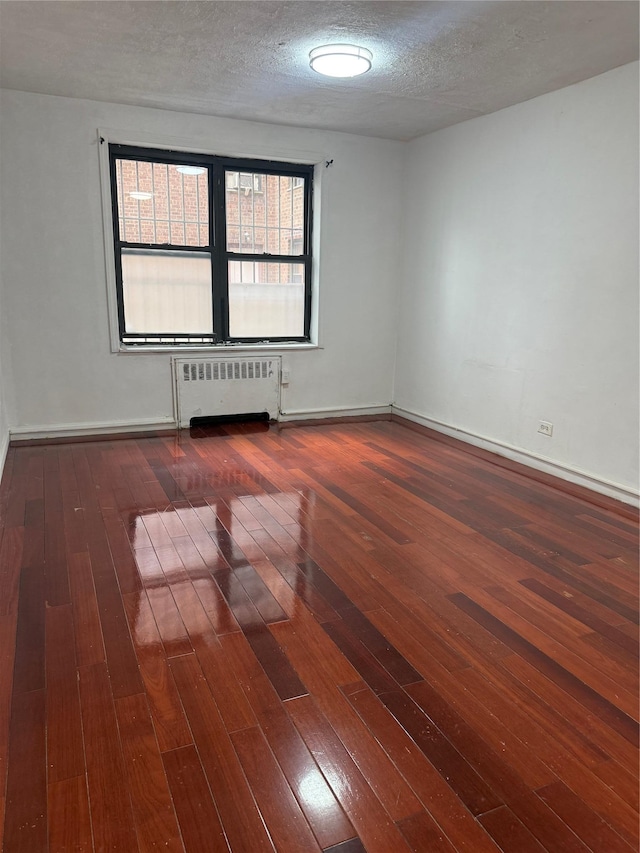 44-11 Macnish St Unit 1E, Elmhurst, NY 11373 - unfurnished room with radiator, hardwood / wood-style floors, baseboards, and a textured ceiling