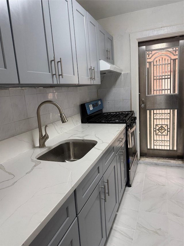 44-11 Macnish St Unit 1E, Elmhurst, NY 11373 - kitchen featuring gas stove, a sink, gray cabinetry, under cabinet range hood, and light stone countertops