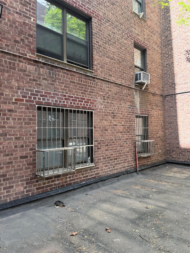 44-11 Macnish St Unit 1E, Elmhurst, NY 11373 - view of side of home featuring cooling unit and brick siding