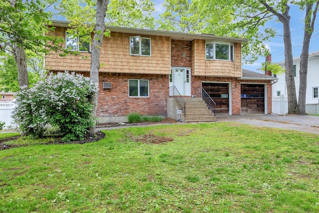 449 Terry Blvd, Holbrook, NY 11741 - bi-level home with asphalt driveway, a front lawn, an attached garage, and brick siding