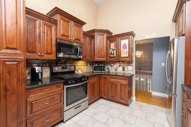 449 Terry Blvd, Holbrook, NY 11741 - kitchen featuring appliances with stainless steel finishes, decorative backsplash, a high ceiling, dark stone countertops, and brown cabinets