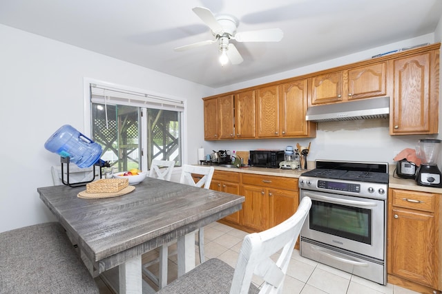 449 Terry Blvd, Holbrook, NY 11741 - kitchen with stainless steel gas range oven, under cabinet range hood, black microwave, brown cabinets, and light countertops