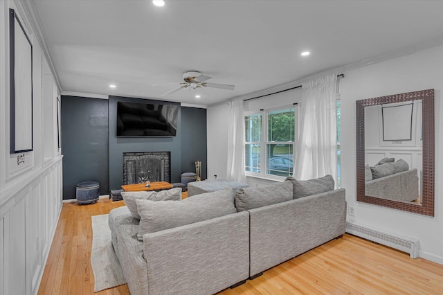 5 Michelle Ln, Selden, NY 11784 - living room featuring a baseboard heating unit, a fireplace, wood finished floors, ornamental molding, and a ceiling fan