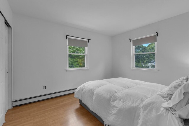 5 Michelle Ln, Selden, NY 11784 - bedroom featuring baseboard heating, multiple windows, wood finished floors, and a closet