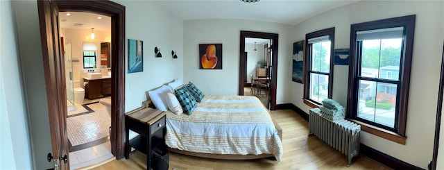 2 Lincoln Ter, Newburgh, NY 12550 - bedroom featuring radiator heating unit, light wood-type flooring, ensuite bath, and baseboards