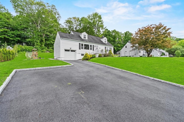 3518 Overlook Ave, Yorktown Heights, NY 10598 - cape cod home featuring a front yard, a playground, asphalt driveway, and an attached garage