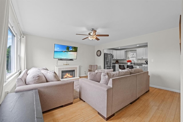 3518 Overlook Ave, Yorktown Heights, NY 10598 - living area featuring light wood finished floors, a glass covered fireplace, ceiling fan, and baseboards