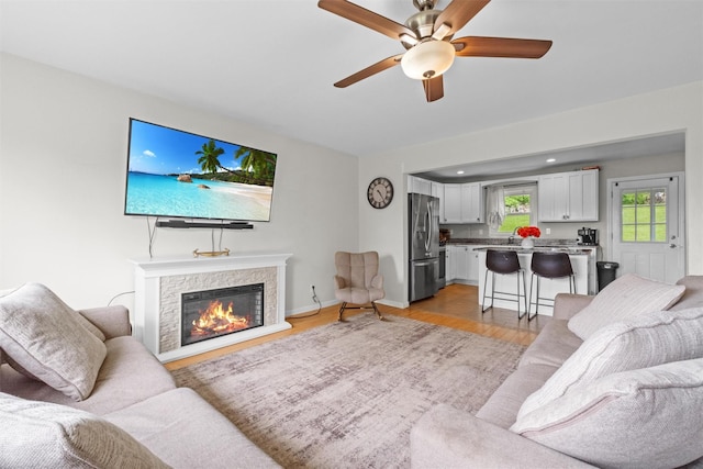 3518 Overlook Ave, Yorktown Heights, NY 10598 - living room with light wood-style flooring, ceiling fan, a stone fireplace, and baseboards