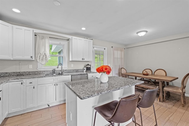 3518 Overlook Ave, Yorktown Heights, NY 10598 - kitchen featuring a sink, wood finish floors, a breakfast bar area, white cabinetry, and recessed lighting