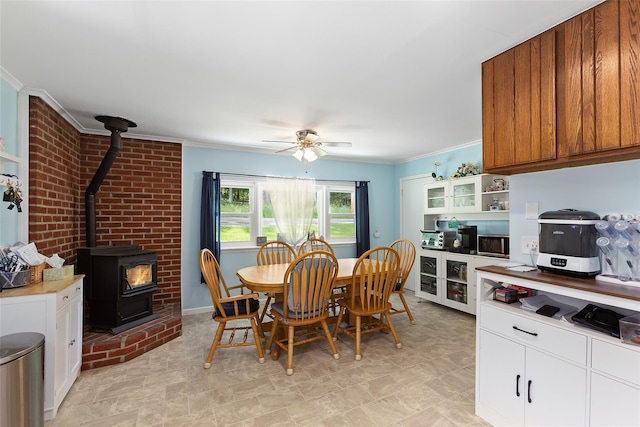 420 Fourth Rd, Wappingers Falls, NY 12590 - dining space featuring a wood stove, crown molding, and a ceiling fan