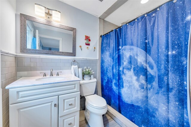 243 Sunflower Ln, Islandia, NY 11749 - bathroom featuring tile walls, toilet, vanity, curtained shower, and wainscoting