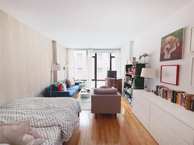 148 E 24th St Unit 5B, New York Manhattan, NY 10010 - bedroom featuring wood finished floors, a wall of windows, and access to outside