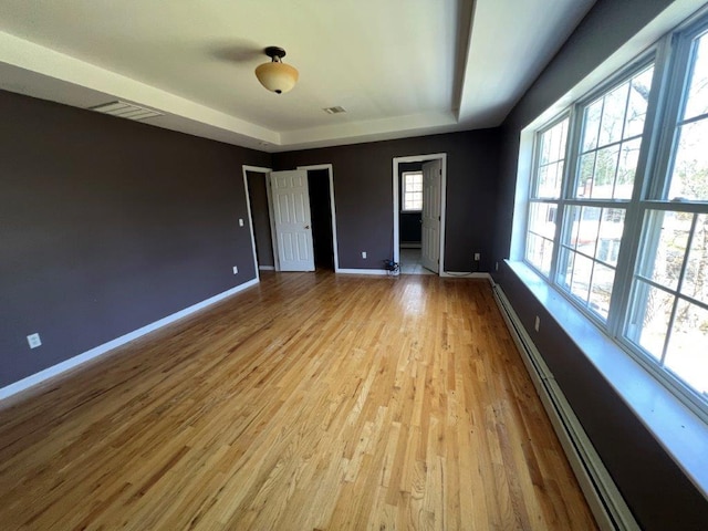 11 Willow Ln, Glen Spey, NY 12737 - empty room featuring a baseboard heating unit, baseboards, a tray ceiling, and light wood-style floors