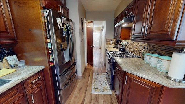30-33 79th St, East Elmhurst, NY 11370 - kitchen featuring gas stove, under cabinet range hood, light wood-type flooring, backsplash, and stainless steel fridge with ice dispenser