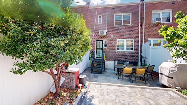 30-33 79th St, East Elmhurst, NY 11370 - rear view of house featuring brick siding, fence, a patio area, and entry steps