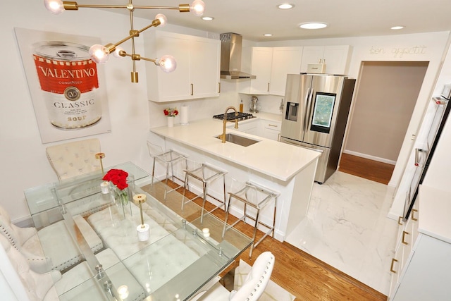 100 Dowd St Unit C12, Haverstraw, NY 10927 - kitchen with stainless steel appliances, wall chimney range hood, white cabinets, a peninsula, and a breakfast bar area