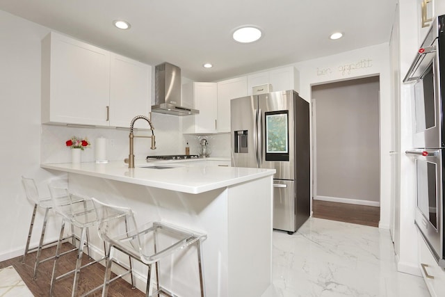 100 Dowd St Unit C12, Haverstraw, NY 10927 - kitchen with wall chimney exhaust hood, appliances with stainless steel finishes, a sink, white cabinetry, and recessed lighting