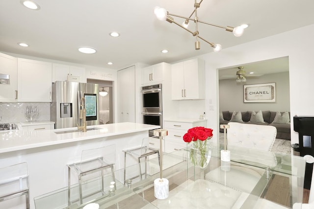 100 Dowd St Unit C12, Haverstraw, NY 10927 - kitchen with appliances with stainless steel finishes, light countertops, a kitchen breakfast bar, white cabinets, and recessed lighting