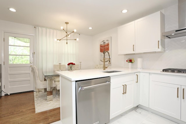100 Dowd St Unit C12, Haverstraw, NY 10927 - kitchen featuring appliances with stainless steel finishes, a sink, wall chimney range hood, a chandelier, and a peninsula