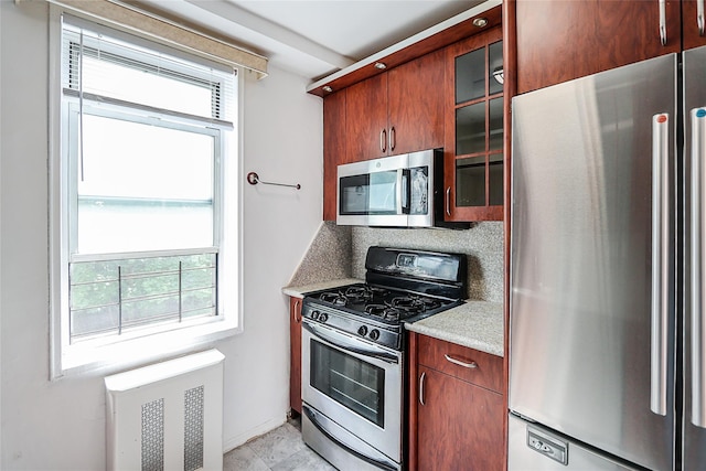 7445 Yellowstone Blvd Unit 5C, Rego Park, NY 11374 - kitchen featuring stainless steel appliances, glass insert cabinets, light countertops, tasteful backsplash, and baseboards