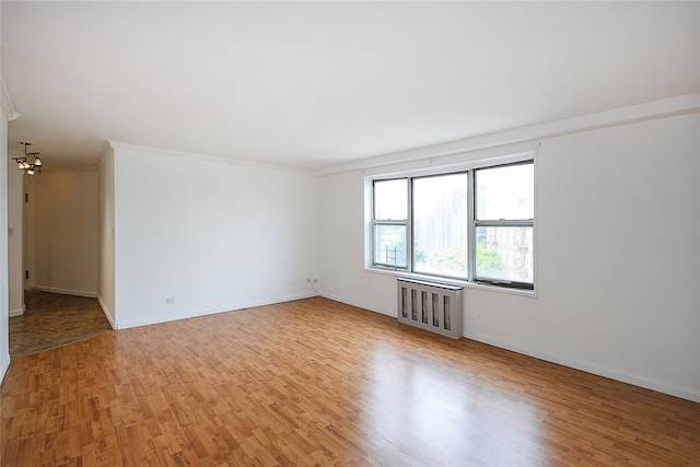 7445 Yellowstone Blvd Unit 5C, Rego Park, NY 11374 - spare room with radiator, light wood-style floors, crown molding, a chandelier, and baseboards