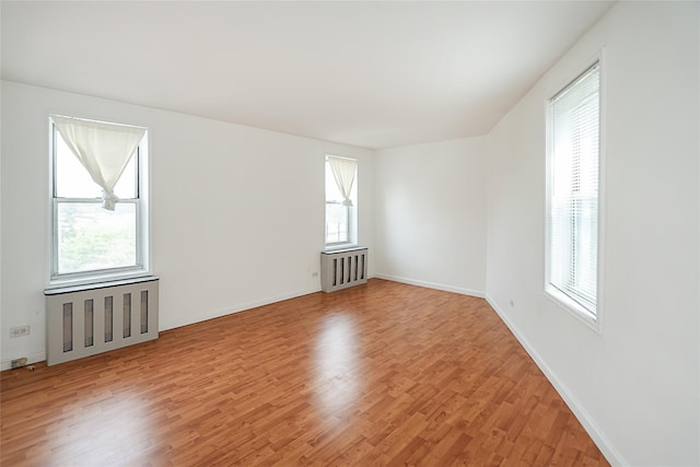 7445 Yellowstone Blvd Unit 5C, Rego Park, NY 11374 - unfurnished room featuring radiator, light wood-style flooring, and baseboards