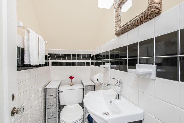 37 Lee Ave, Yonkers, NY 10705 - half bathroom with tile walls, a sink, toilet, and tasteful backsplash