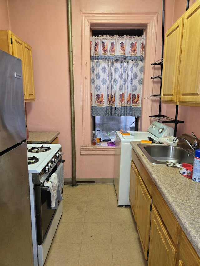 79 Hamilton Pl Unit 5, New York Manhattan, NY 10031 - kitchen featuring freestanding refrigerator, white range with gas stovetop, washer / clothes dryer, a sink, and baseboards