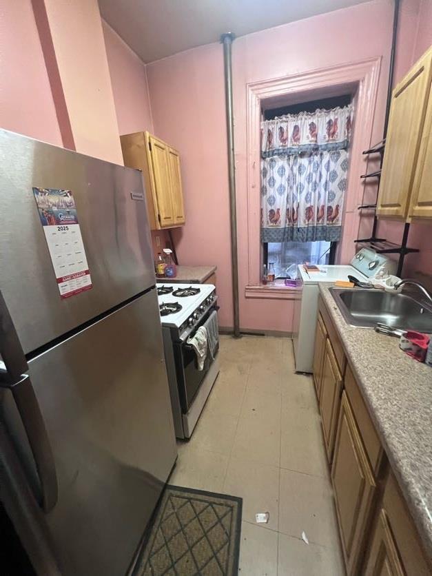 79 Hamilton Pl Unit 5, New York Manhattan, NY 10031 - kitchen featuring freestanding refrigerator, gas range, washer / clothes dryer, a sink, and light countertops