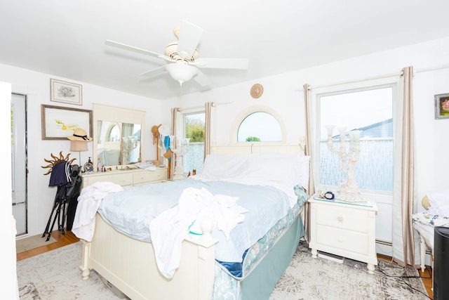 849 E Bay Dr, West Islip, NY 11795 - bedroom featuring baseboard heating, a ceiling fan, and light wood-style floors