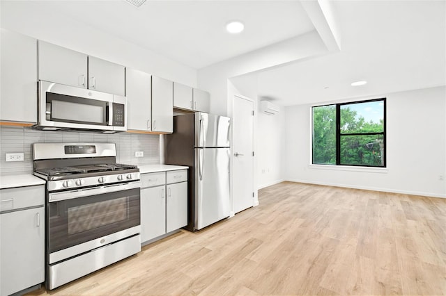 1727 Lacombe Ave Unit 2B, Bronx, NY 10473 - kitchen featuring stainless steel appliances, light countertops, tasteful backsplash, light wood finished floors, and gray cabinetry