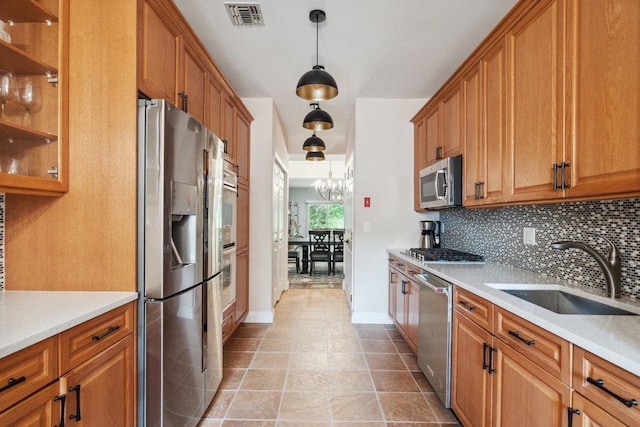 76 Sagamore Dr, Plainview, NY 11803 - kitchen featuring appliances with stainless steel finishes, a sink, backsplash, and brown cabinetry
