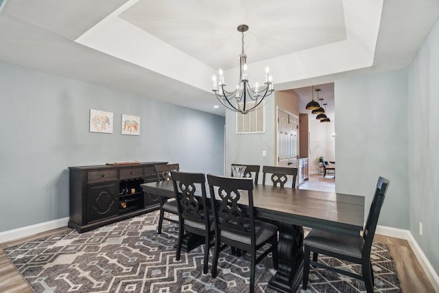 76 Sagamore Dr, Plainview, NY 11803 - dining space with a chandelier, wood finished floors, baseboards, and a raised ceiling
