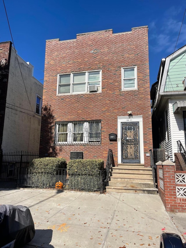 108-41 51st Ave, Corona, NY 11368 - view of front facade with brick siding, cooling unit, and entry steps