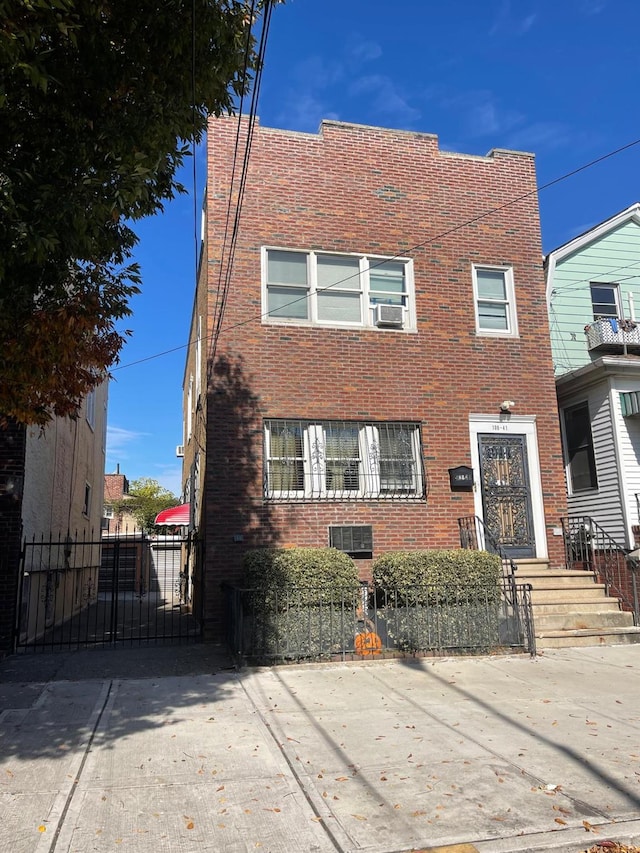 108-41 51st Ave, Corona, NY 11368 - view of front facade with brick siding, a gate, and cooling unit