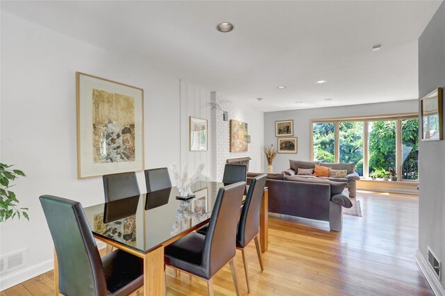 1 Exeter Pl, Glen Head, NY 11545 - dining room featuring light wood-style flooring, a brick fireplace, recessed lighting, and baseboards