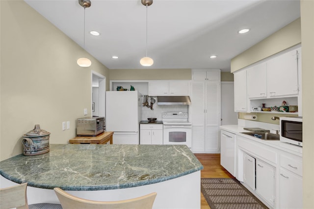 1 Exeter Pl, Glen Head, NY 11545 - kitchen with white appliances, under cabinet range hood, a peninsula, light wood-type flooring, and white cabinets