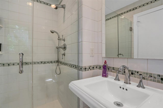 1 Exeter Pl, Glen Head, NY 11545 - bathroom with a shower stall, a sink, tile walls, and decorative backsplash